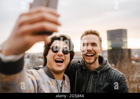 Fröhliche männliche Freunde, die Selfie auf dem Smartphone machen Stockfoto