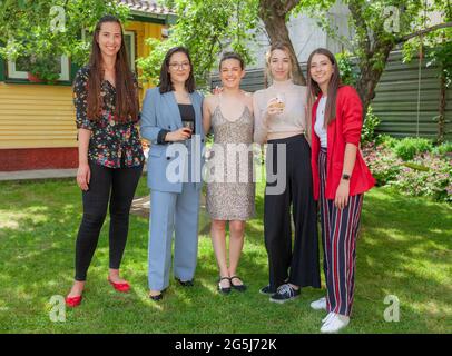 Fünf schöne Teenager-Mädchen feiern die Abschlussfeier posieren für Bild im Frühling oder Sommer Zeit lächeln an der Kamera. Stockfoto