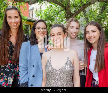 Fünf schöne Teenager-Mädchen feiern die Abschlussfeier posieren für Bild im Frühling oder Sommer Zeit lächeln an der Kamera. Stockfoto