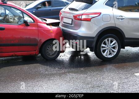 Der Stoßfänger, die Scheinwerfer und die Motorhaube sind gebrochen. Ein Autounfall auf der Straße mit beschädigten Autos nach einer Kollision Stockfoto