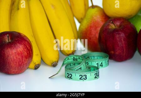 Set aus frischen Früchten, gesunden Früchten mit Maßband auf weißem Hintergrund. Diät-Konzept Stockfoto