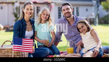 Zusammensetzung der amerikanischen Flagge, über lächelnde Familie sitzen auf Gras beim Picknick Stockfoto