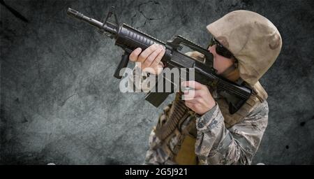 Zusammensetzung des männlichen Soldaten trägt Sonnenbrille zeigt Pistole, gegen Rauch auf schwarz Stockfoto