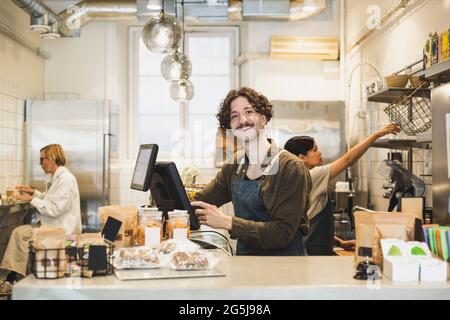 Porträt eines männlichen Besitzers, der im Geschäft am Computer arbeitet Stockfoto