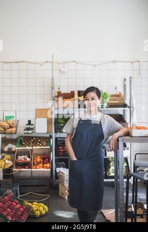 Porträt einer lächelnden Unternehmerin mit der Hand in der Tasche im Geschäft Stockfoto