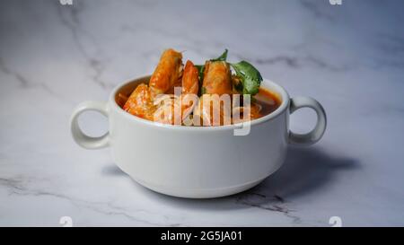 Tom Yum Goong würzige Sour-Suppe isoliert auf weißem Marmor Hintergrund, thailändische lokale Küche. Stockfoto