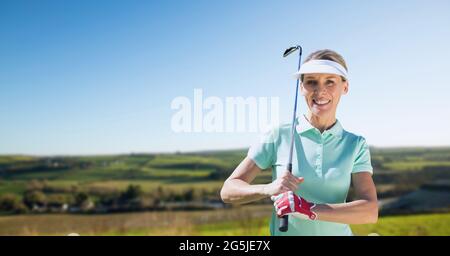 Zusammensetzung der weiblichen Golfspielerin, die den Club im Freien hält Stockfoto