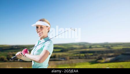 Zusammensetzung der weiblichen Golfspielerin, die den Club im Freien hält Stockfoto