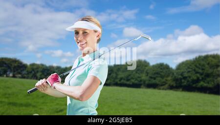 Zusammensetzung der weiblichen Golfspielerin, die den Club im Freien hält Stockfoto