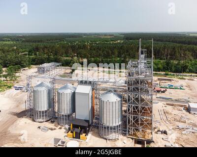 Luftaufnahme des riesigen modernen Getreideaufzugs. Lagerung von Lebensmitteln, Gebäude in Arbeit. Silofarm. Entwicklung der Agrarindustrie. Stockfoto