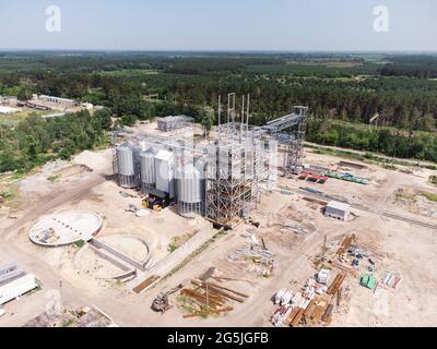 Luftaufnahme des riesigen modernen Getreideaufzugs. Lagerung von Lebensmitteln, Gebäude in Arbeit. Silofarm. Entwicklung der Agrarindustrie. Stockfoto