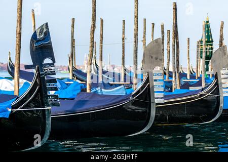 Traditionelle venezianische Gondeln, die an einem ruhigen Morgen vor dem Markusplatz in Venedig, Italien, festgemacht wurden Stockfoto