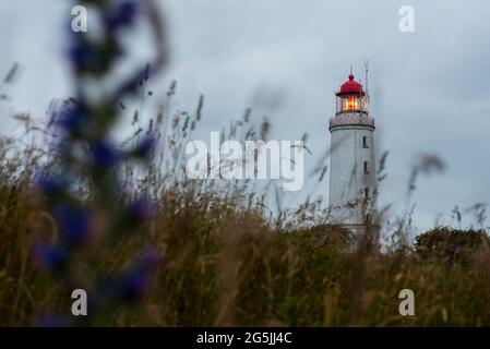 25. Juni 2021, Mecklenburg-Vorpommern, Hiddensee: Wolken ziehen während des Sonnenaufgangs über den Leuchtturm am Briarfleck. Foto: Stephan Schulz/dpa-Zentralbild/ZB Stockfoto