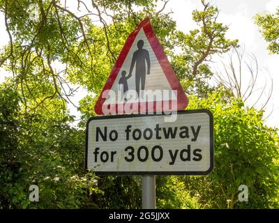 Ein Straßenschild, das anzeigt, dass es für 300 Yds keinen Fußraum gibt, mit Wörtern und einem Erwachsenen- und Kindersymbol in einem roten Warndreieck Stockfoto