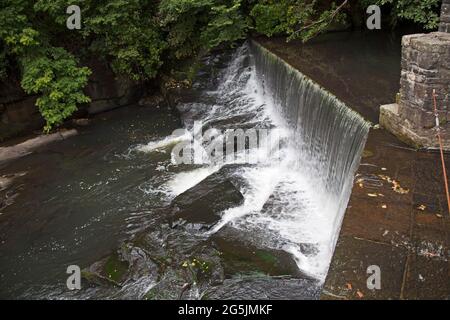 Wasser, das über einen künstlichen Steinwasserfall oder Wehr fließt, wird vom Aberdulais Waterwheel, Neath, Wales, abgeleitet Stockfoto