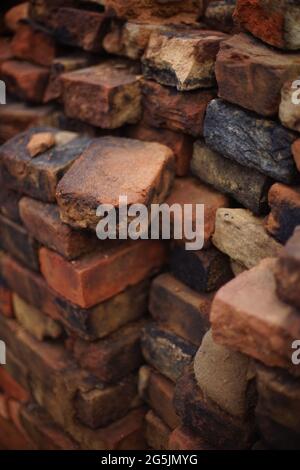 Stapel von antiken irdenen rot-schwarzen Ziegeln Hintergrund. Stockfoto