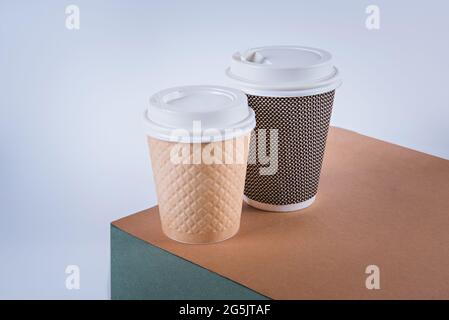 Zwei handbesetzbare Einweg-Kaffeetassen aus Papier. Umweltschutzkonzept. Stockfoto
