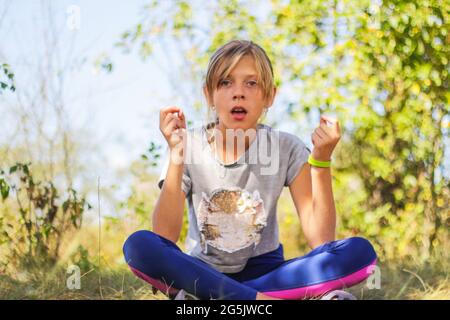 Defocus caucasian preteen Mädchen praktiziert Yoga im Park, Wald, im Freien, draußen. Meditation, Konzentration, Mantra. Wellness-Lifestyle. Porträt von Stockfoto