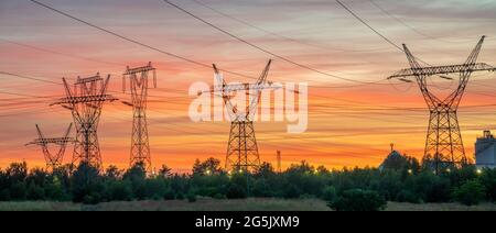Hochspannungsmasten vor dem Hintergrund des Abendhimmels Stockfoto
