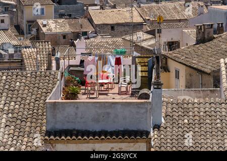 Trocknen von Kleidung auf einer Wäscheleine im Freien. Häuser mit traditionellen Dachziegeln in der schönen Altstadt von Arta, Mallorca, Spanien. Mediterrane Kultur. Stockfoto