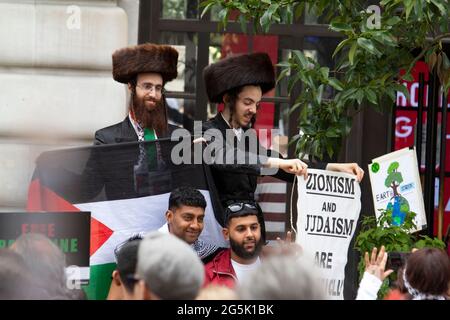 Ultra-orthodoxe Juden der Neturei Karta Division aus Stamford Hill, die gegen den Zionismus unter palästinensischen Flaggen zusammengeschlossene orthodoxe Juden repräsentieren, nehmen an der Volksversammlung National Demonstration in London Teil. Rabbi Blyer befindet sich auf der linken Seite Stockfoto