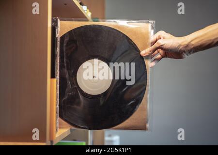 Eine Schallplatte aus einem Regal auswählen Stockfoto
