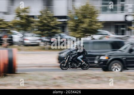 Ukraine, Kiew - 27. Juni 2021: Schwarzes Motorrad bewegt sich auf der Straße. Redaktionell Stockfoto