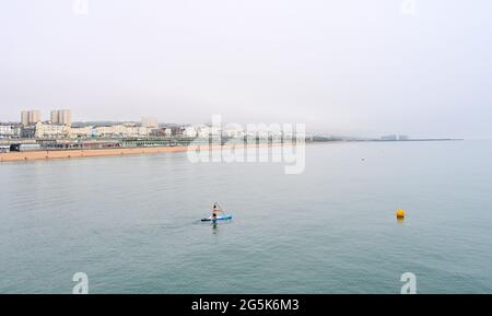 Brighton UK 28. Juni 2021 - EIN Paddelboarder hat in Brighton an einem warmen, aber nebligen Nachmittag an der Südküste das Meer für sich alleine : Credit Simon Dack / Alamy Live News Stockfoto
