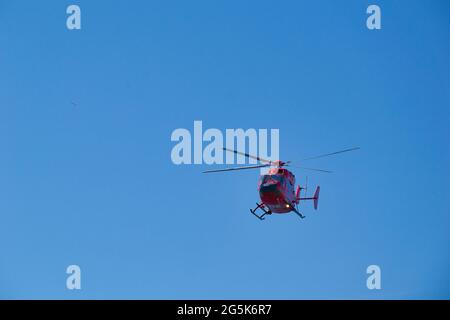 Kleiner roter Hubschrauber im Tiefflug Stockfoto