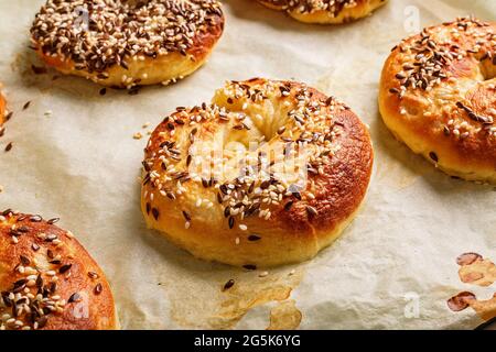 Frische und knusprige New York Bagels mit Sesam. Hausgemachtes Backen. Heiße Bagels auf Backpapier. Kochen Sie zu Hause. Die beste hausgemachte New York-Stil Bagel Stockfoto