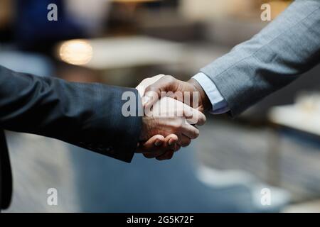 Nahaufnahme von zwei erfolgreichen Geschäftsleuten, die in der Lobby des Bürogebäudes die Hände schütteln, Kopierfläche Stockfoto