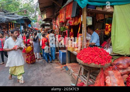 Kolkata, Westbengalen, Indien - 15. April 2019 : Hibiskusblüten, rote Saris und andere Gottesdienste werden an bengalische Anhänger in Kalighat verkauft Stockfoto