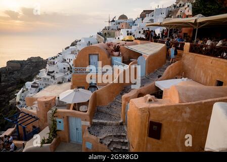 Windmühle und Kuppelkirche im Dorf Oia auf der Insel Santorin, Griechenland. Stockfoto