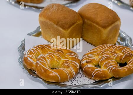 Frisch gebackenes Brot, Brezeln, Kringles auf dem Teller in der Bäckerei Stockfoto