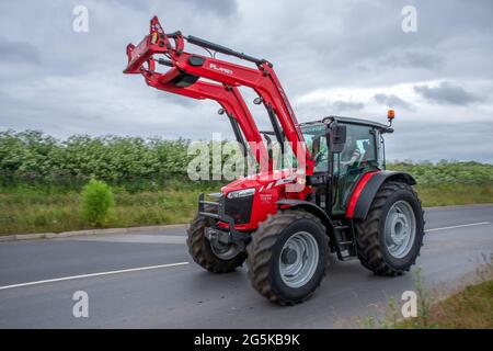 27. Juni 2021 - Pocklington, East Yorkshire, UK - Beacon Young Farmers Club Tractor Run. Roter Massey Ferguson-Traktor mit angehobenem Ausleger. Stockfoto