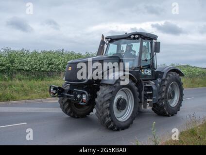 27. Juni 2021 - Pocklington, East Yorkshire, UK - Beacon Young Farmers Club Tractor Run. Schwarz und grau großer Traktor auf der Autobahn. Stockfoto