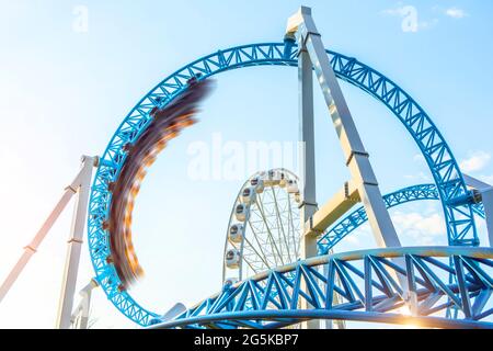 Mit dem Motion-Unschärfe-Geschwindigkeitseffekt von „Amusement Trolley“ wird die Kreisschleife auf den Kopf gestellt, eine Achterbahn. Verängstigte Gesichter von Menschen, die auf Karren Buße taten Stockfoto