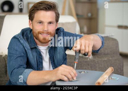 Talentierte junge Holzarbeiter, die einen Stuhl befestigen Stockfoto