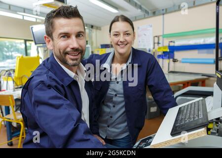 Porträt von Arbeiterinnen und Arbeitern in blauen Staubjacken Stockfoto