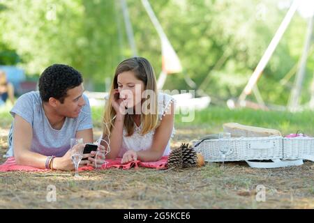 Das Paar lag auf dem Boden in der Nähe des Wassers Stockfoto