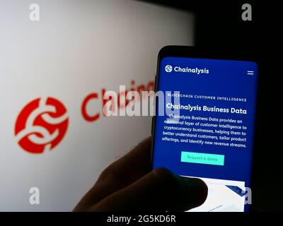 Person, die Mobiltelefon mit der Webseite des US-Kryptowährungsunternehmens Chainalysis Inc. Auf dem Bildschirm vor dem Logo hält. Konzentrieren Sie sich auf die Mitte des Telefondisplays. Stockfoto
