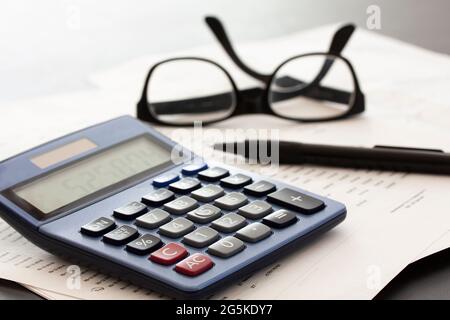 Taschenrechner, Brille, Stift und Papier auf weißem Hintergrund mit Platz für Kopien. Geschäftskonzept. Stockfoto