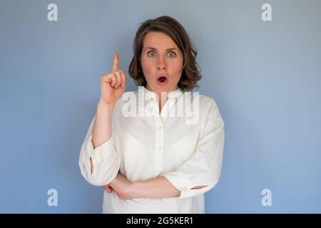 Überraschte Frau, die auf ihren Finger zeigt, während sie dich anschaut Stockfoto