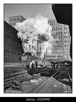 Vintage Steam Engine Locomotive Railway USA Chicago, Illinois. Doppel-Header-Lokomotiven / Lokomotiven Pennsylvania Eisenbahnzug zieht aus Union Station. Das Gebäude im Hintergrund ist US Post Office Jack Delano Fotograf 1943 Jan. USA--Illinois--Cook County--Chicago US Farm Security Administration/ Office of war Information Black & White USA Stockfoto