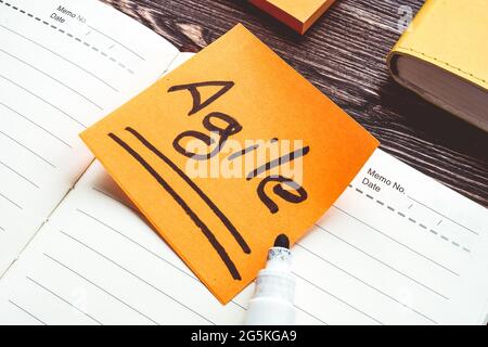 Aufkleber mit World Agile im offenen Notizblock. Stockfoto
