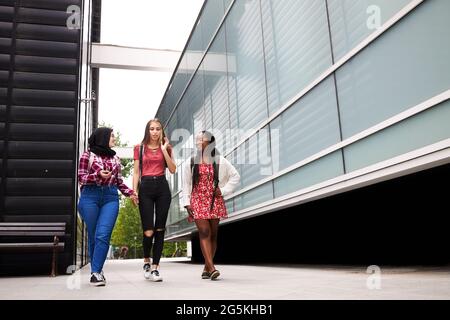 Junge Studenten unterhalten sich und hängen sich auf dem Universitätscampus ab Stockfoto