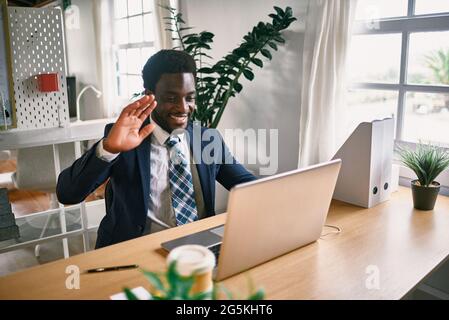 Junger afrikanischer Mann, der Videokonferenz im modernen Büro macht - Fokus auf Gesicht Stockfoto