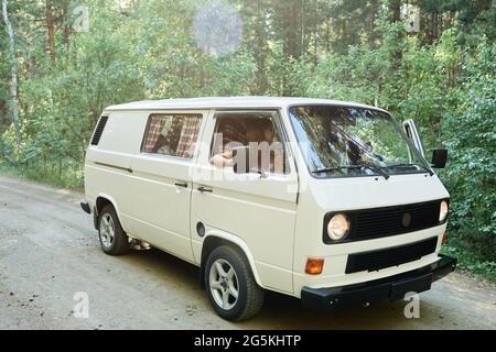 Menschen, die zusammen mit dem Van unterwegs sind, fahren im Wald Stockfoto