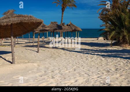 Blick auf den weißen Sandstrand und die Sonnenschirme an der Mittelmeerküste mit Birkenwasser. Stockfoto