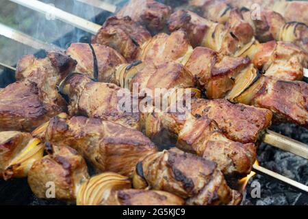 Schweinespieße auf einem Metallspieß aufgereiht und auf dem Grill braten Stockfoto